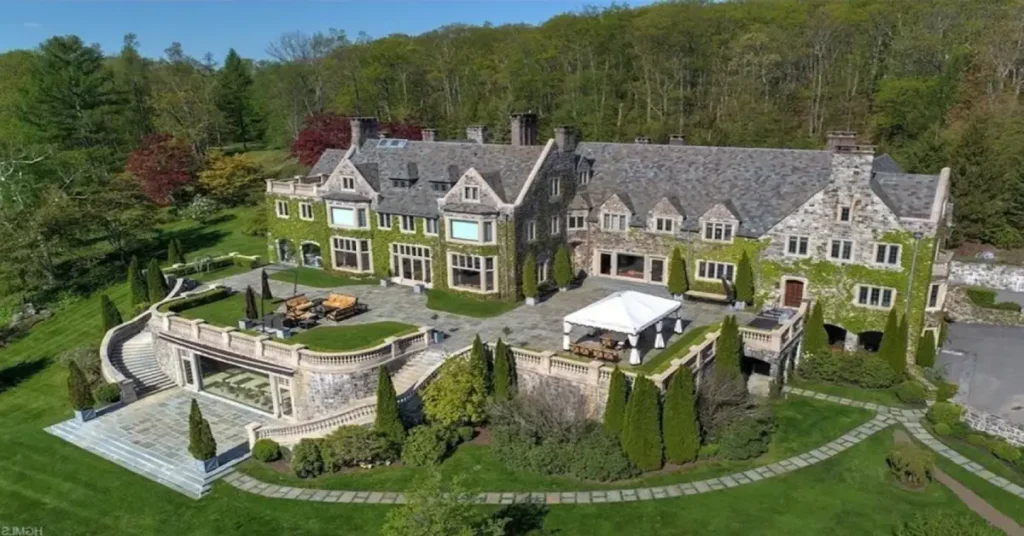 Andrew Carnegie House: Aerial view of a grand stone mansion with ivy-covered walls surrounded by manicured gardens, exemplifying the steel magnate's Gilded Age estate