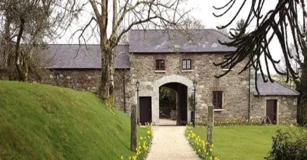 Front view of the Gemma Arterton House showcasing its rustic stone architecture and peaceful garden, embodying the actress’s countryside living.